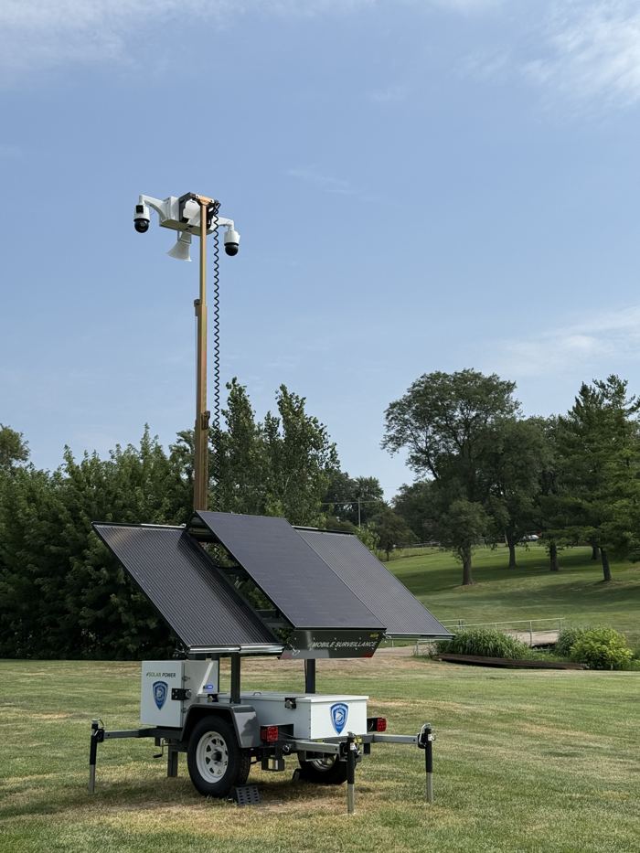 Frontline three-panel solar camera trailer with mast raised on a grass lawn