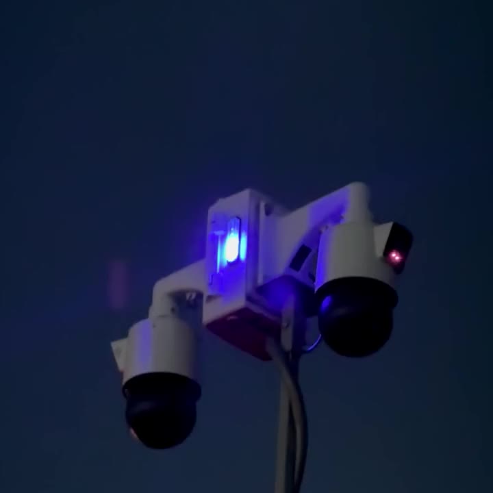 Trailer mast PTZ cameras with blue strobe lit at night